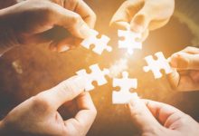 Hand of diverse people connecting jigsaw puzzle. Concept of partnership and teamwork in business